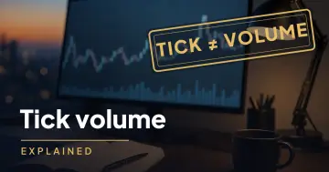 Monitor showing a price chart with volume bars on a trading desk