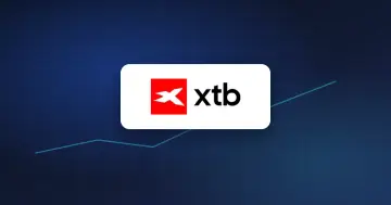 Logo brokera XTB na tmavomodré kartě se stoupající linkou, ilustrace k předběžným pololetním výsledkům